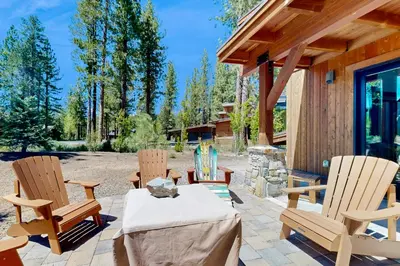 a patio with three chairs and a table and a house at Henness Escape in Truckee