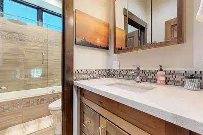 a bathroom with a sink and a toilet and mirrors at Henness Escape in Truckee