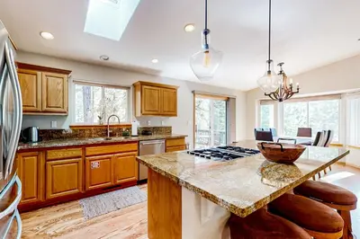 a kitchen with wooden cabinets and a granite counter top at Sunlit Forest Haven in South Lake Tahoe