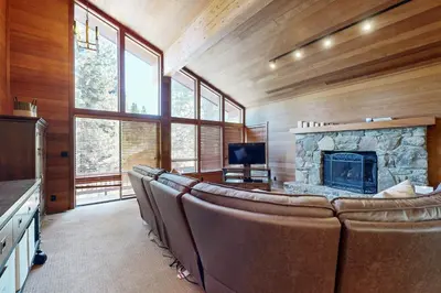a living room with leather chairs and a stone fireplace at Amazing Dollar Point Retreat in Tahoe City