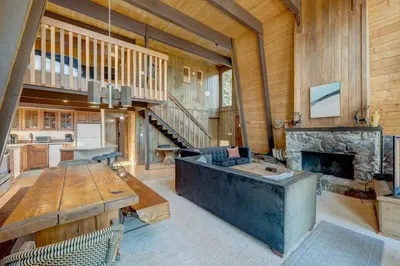 a large living room with a stone fireplace and a table at Dollar Point in Tahoe City