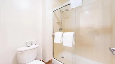 a white bathroom with a toilet and a shower at Mammoth Green 118 Located on Sierra Star Golf Course, Private Patio, Summer Pool condo in Mammoth Lakes