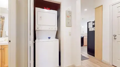 a kitchen with a washer and a white refrigerator at Mammoth Green 118 Located on Sierra Star Golf Course, Private Patio, Summer Pool condo in Mammoth Lakes