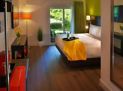 a bedroom with a bed with a yellow blanket on it at Foothills Motel in Auburn