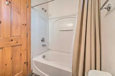 a bathroom with a bath tub and a shower curtain at 2 Mi to Donner Lake Walkable Truckee Condo! in Truckee