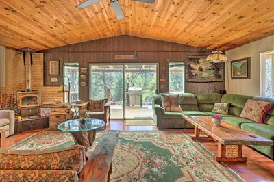 a living room with a couch and a table at Gorgeous Oakhurst Retreat with Swimming Hole! in Oakhurst
