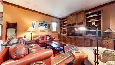 a living room with leather furniture and a large tv at Lodestar #2001 home in Mammoth Lakes