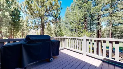 a cart on a deck with a fence and trees at Lodestar #2001 home in Mammoth Lakes