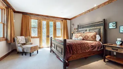 a bedroom with a bed and a chair and windows at Lodestar #2001 home in Mammoth Lakes
