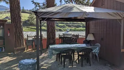 a table and chairs under an umbrella on a patio at Room #3 at the Apple Place in Miramonte