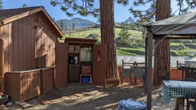 a small shed with a kitchen and a table at Room #3 at the Apple Place in Miramonte