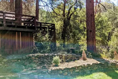 a garden with a bridge and a stone wall at Pierce's Cabin in Miramonte