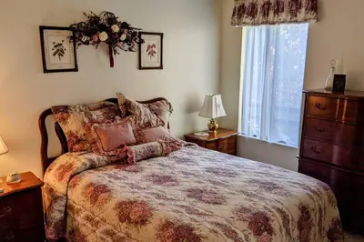 a bedroom with a bed and a dresser and a window at Pierce's Cabin in Miramonte