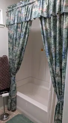 a bathroom with a shower curtain and a bath tub at Pierce's Cabin in Miramonte