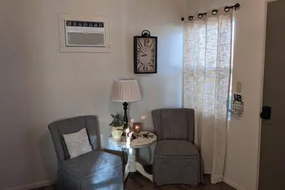 a room with two chairs and a table and a clock at Cozy Cabin in Squaw Valley