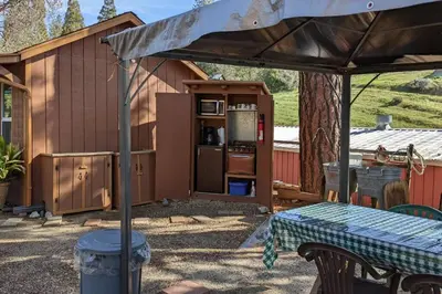 an outdoor kitchen with an umbrella next to a building at The Apple Place Room #2 in Miramonte