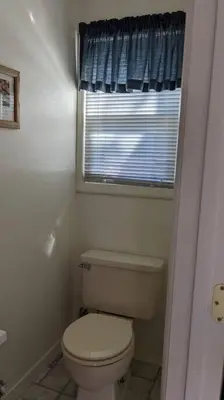 a bathroom with a white toilet and a window at The Apple Place Room #2 in Miramonte