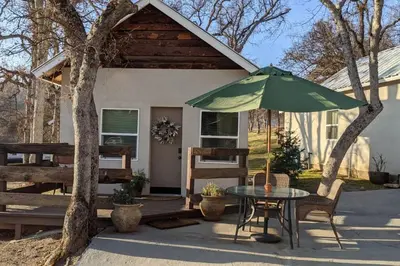 a table with a green umbrella in front of a house at Sweet Mountain Cabin in Squaw Valley