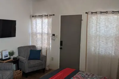 a bedroom with a bed and a chair and a door at Sweet Mountain Cabin in Squaw Valley
