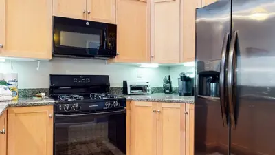 a kitchen with wooden cabinets and a stainless steel refrigerator at Mammoth Green #205 condo in Mammoth Lakes