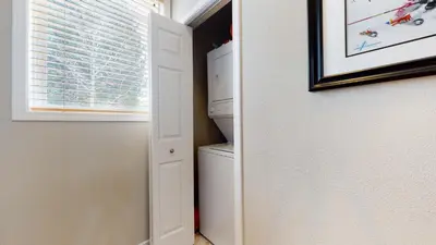 a laundry room with a white refrigerator and a window at Mammoth Green #205 condo in Mammoth Lakes