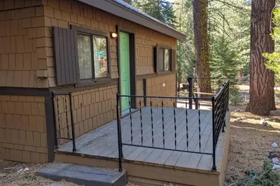 a cabin with a porch with a green door at King's Cabin in Wilsonia