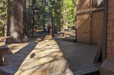 a walkway next to a building with trees in the background at King's Cabin in Wilsonia