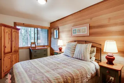 a bedroom with a bed and two lamps and a window at Mill Camp Gem in Ponderosa Fairway Estates