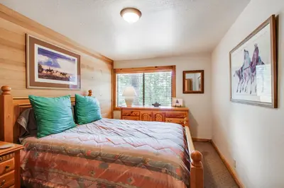 a bedroom with a bed and a desk and a window at Mill Camp Gem in Ponderosa Fairway Estates