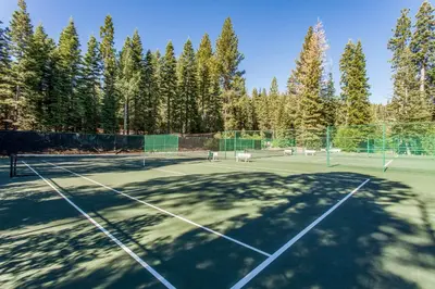 a tennis court with trees in the background at Gold Bend Adventure in Truckee