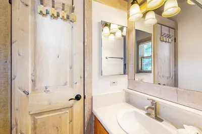 a bathroom with a sink and a mirror and a door at Gold Bend Adventure in Truckee