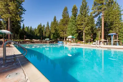 a swimming pool with blue water and trees at Gold Bend Adventure in Truckee