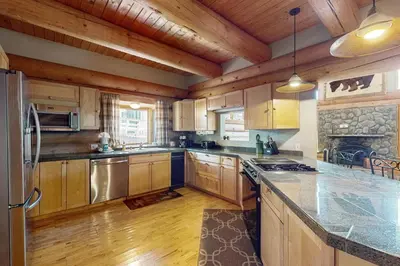 a kitchen with wooden cabinets and stainless steel appliances at Marshall Haven in South Lake Tahoe