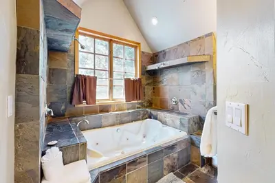 a large bathroom with a tub and a window at Marshall Haven in South Lake Tahoe