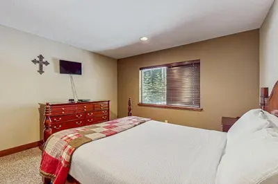 a bedroom with a bed and a dresser and a window at Miztec Charms in South Lake Tahoe