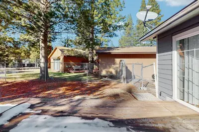 a giraffe behind a fence in front of a house at Apache Adventures in South Lake Tahoe