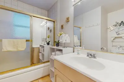 a white bathroom with a sink and a mirror at Apache Adventures in South Lake Tahoe