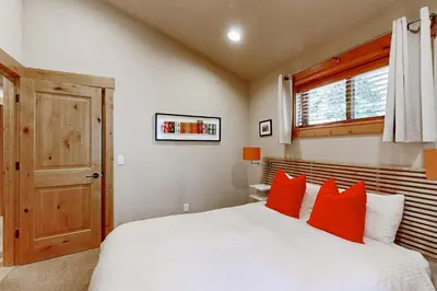 a bedroom with a white bed with red pillows at Oslo Oasis in Truckee