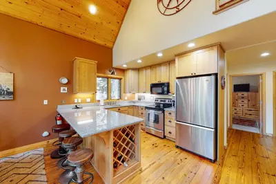 a large kitchen with wooden cabinets and a refrigerator at Fawn Haven in Truckee