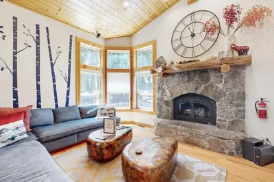 a living room with a couch and a fireplace at Wooded Luxury at Tahoe Donner in Truckee
