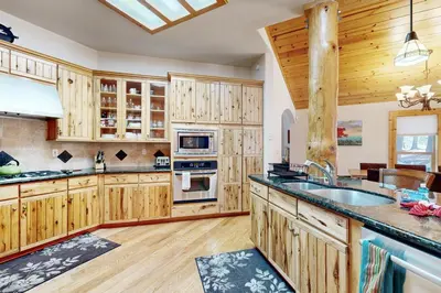 a large kitchen with wooden cabinets and a sink at Wooded Luxury at Tahoe Donner in Truckee