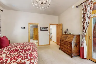 a bedroom with a large bed and a chandelier at Wooded Luxury at Tahoe Donner in Truckee