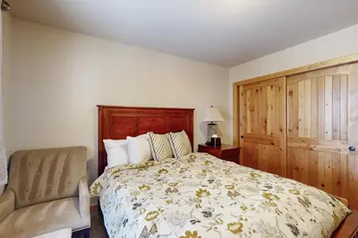 a bedroom with a bed and a chair at Wooded Luxury at Tahoe Donner in Truckee