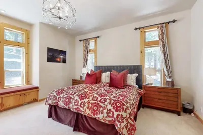 a bedroom with a large bed with red pillows at Wooded Luxury at Tahoe Donner in Truckee