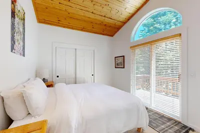 a bedroom with a bed and a large window at Tyrol Getaway in Truckee