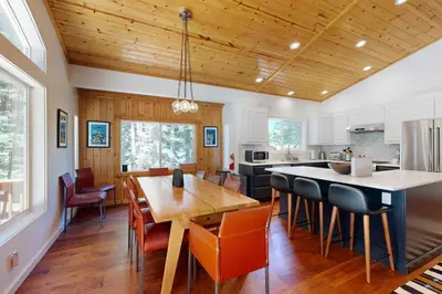 a kitchen and dining room with a wooden ceiling at Tyrol Getaway in Truckee