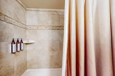 a bathroom with a shower with two bottles of wine at Cougar Haven in South Lake Tahoe