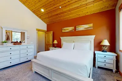 a bedroom with a white bed and orange walls at Marshall Escape in South Lake Tahoe