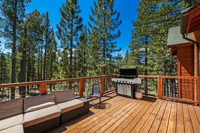 a deck with a couch and a grill at Marshall Escape in South Lake Tahoe