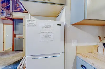 a white refrigerator in a kitchen with a staircase at Cabin Oasis in Tahoma